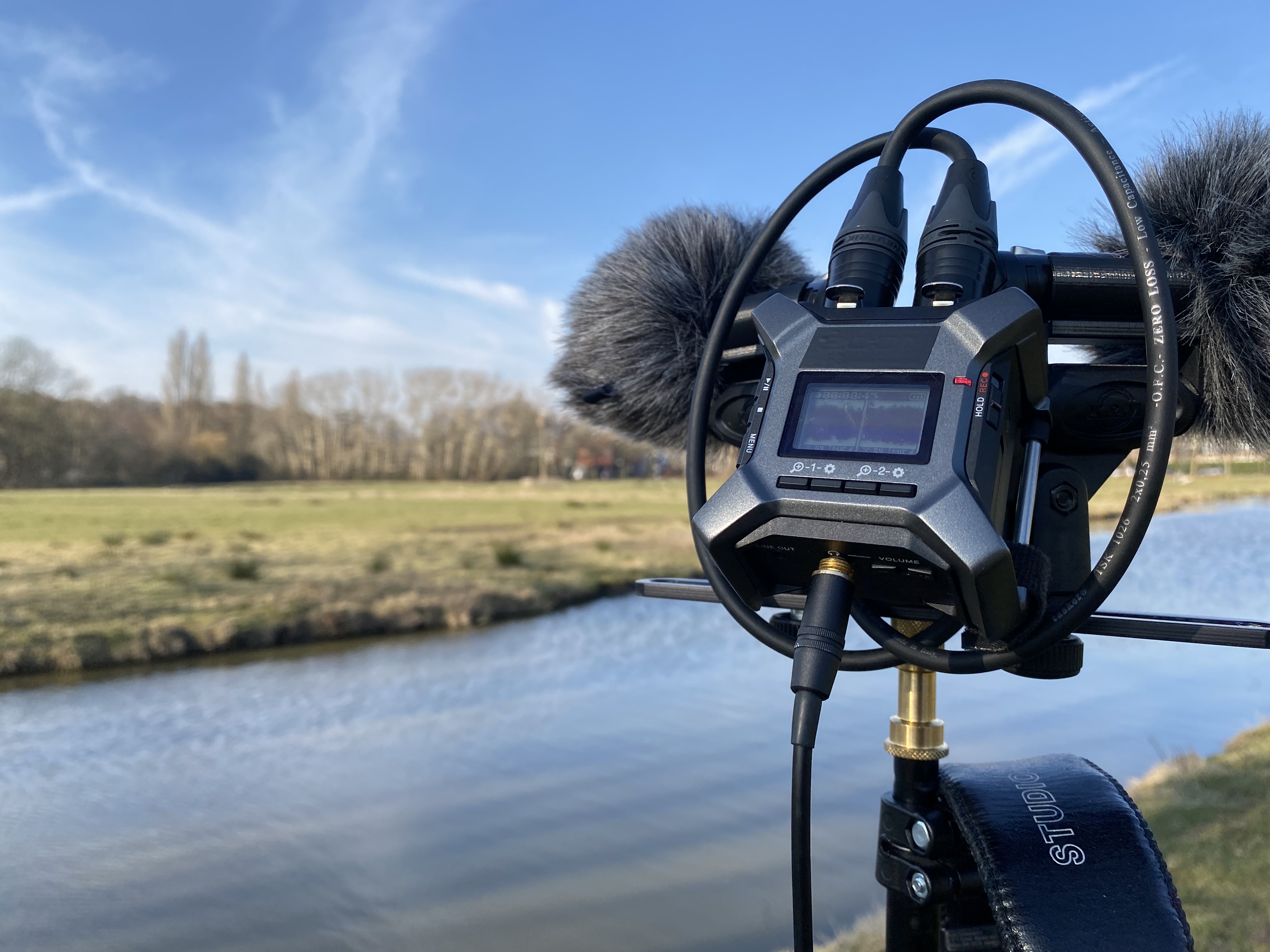 Field recording setup: tripod, recorder, and microphones